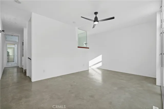 an empty room with a ceiling fan and window