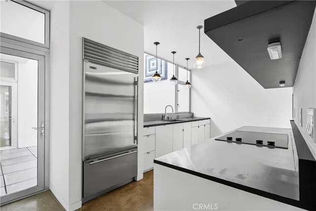 a kitchen with a refrigerator and white cabinets