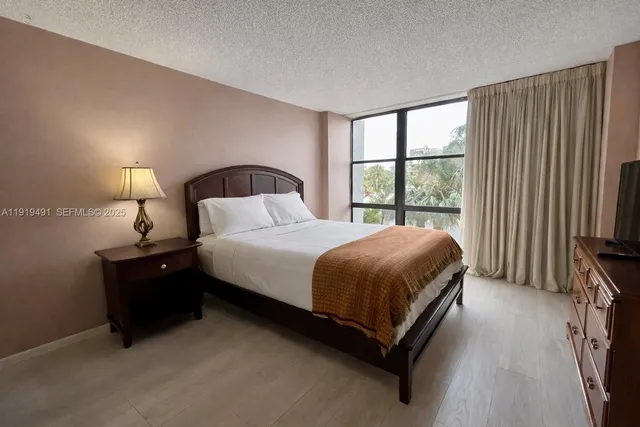 a bedroom with a bed and a large window