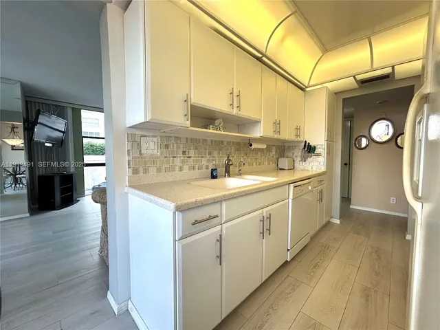 a kitchen with a sink cabinets and wooden floor
