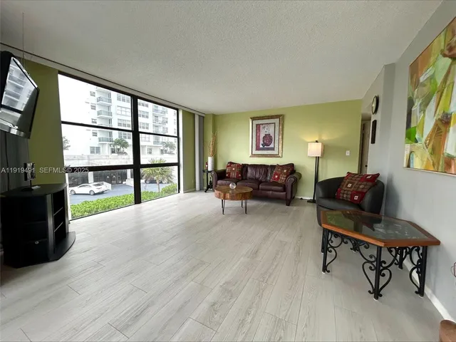 a living room with furniture and a floor to ceiling window