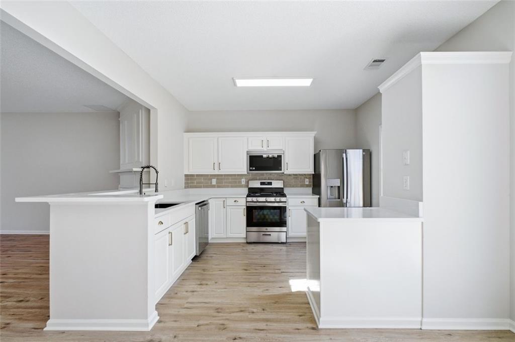 5764 Reps Trace Norcross, GA 30071 - Photo 13 of 32 a kitchen with stainless steel appliances a stove top oven a sink a counter top space and cabinets