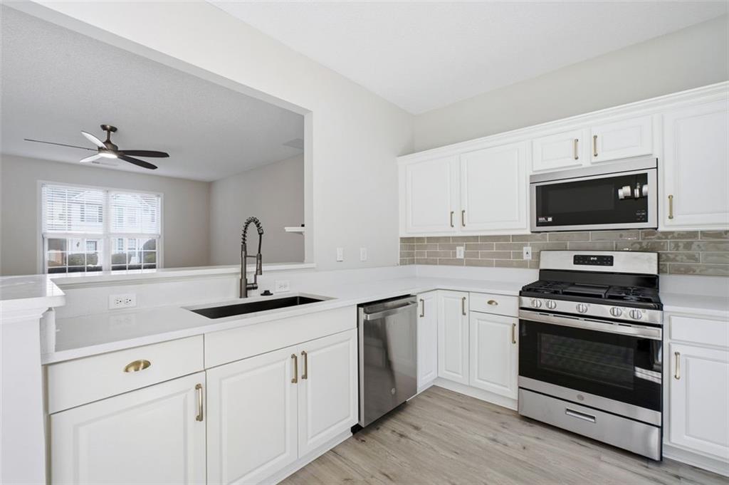 5764 Reps Trace Norcross, GA 30071 - Photo 14 of 32 a kitchen with white cabinets stainless steel appliances and sink
