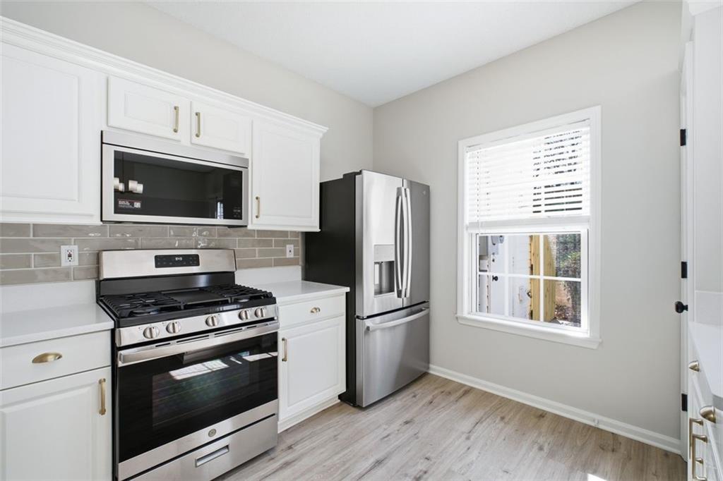 5764 Reps Trace Norcross, GA 30071 - Photo 16 of 32 a kitchen with granite countertop a refrigerator stove and microwave