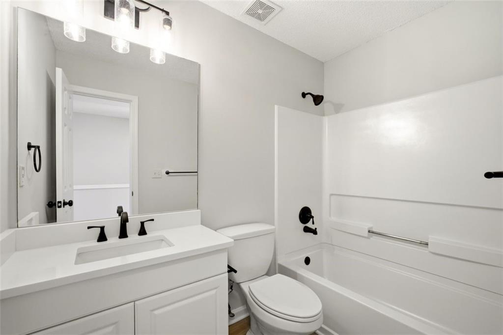 5764 Reps Trace Norcross, GA 30071 - Photo 29 of 32 a bathroom with a bathtub shower sink vanity mirror and toilet