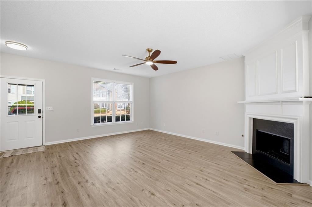 5764 Reps Trace Norcross, GA 30071 - Photo 8 of 32 an empty room with wooden floor a ceiling fan and windows