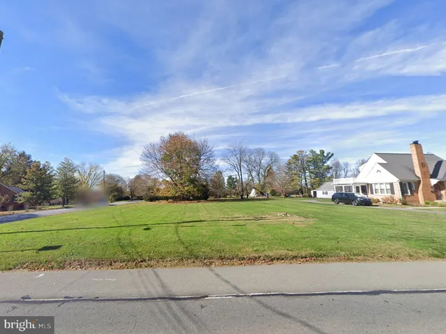 a view of a big yard with a house in the background