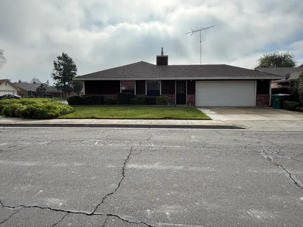a front view of a house with a yard and a garage