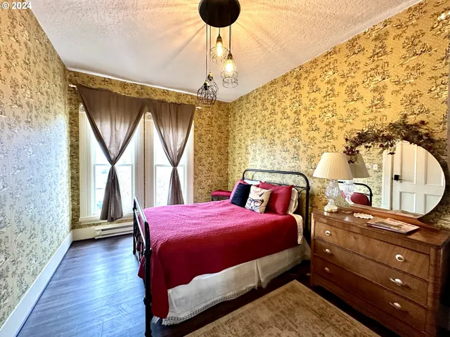 a bedroom with a bed dresser and a window