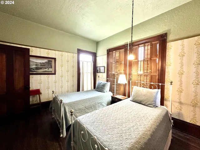 a large bedroom with two beds and large window