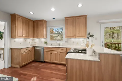 a kitchen with stainless steel appliances a stove and white cabinets