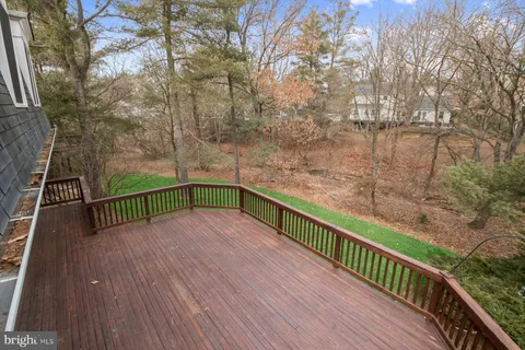 a view of deck with wooden floor and fence with a bench