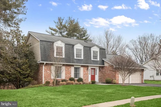 a front view of a house with a garden and trees