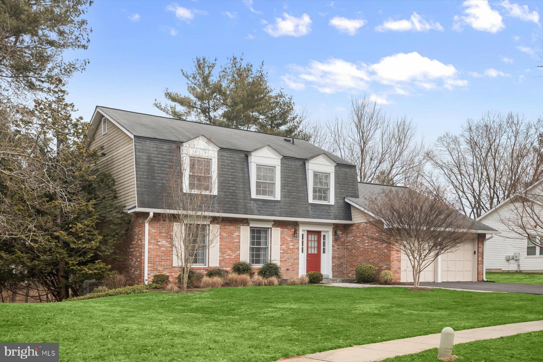 1727 Glastonberry Road Potomac, MD 20854 - Photo 2 of 45 a front view of a house with a garden and trees
