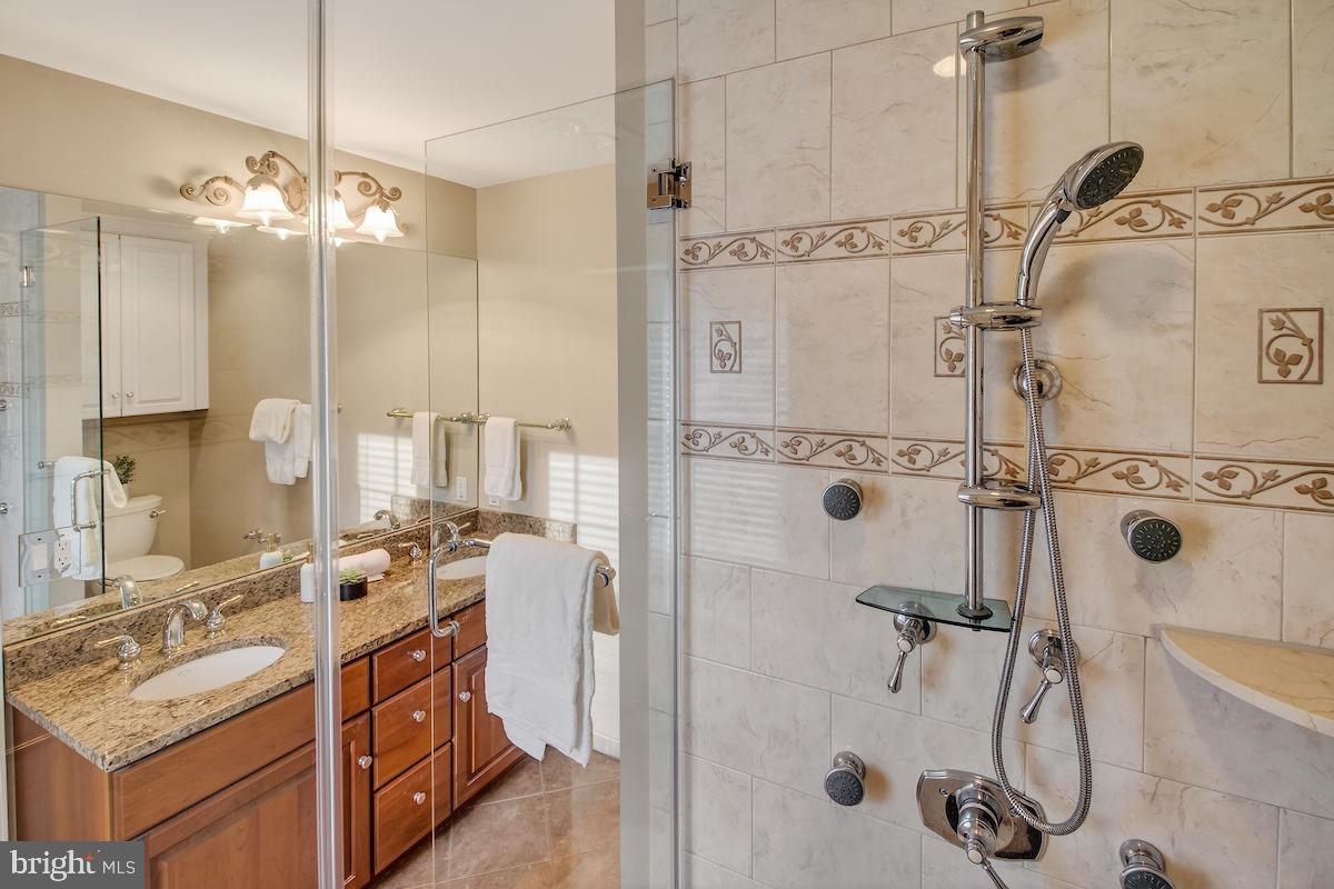 1727 Glastonberry Road Potomac, MD 20854 - Photo 30 of 45 a bathroom with a double vanity sink mirror and shower
