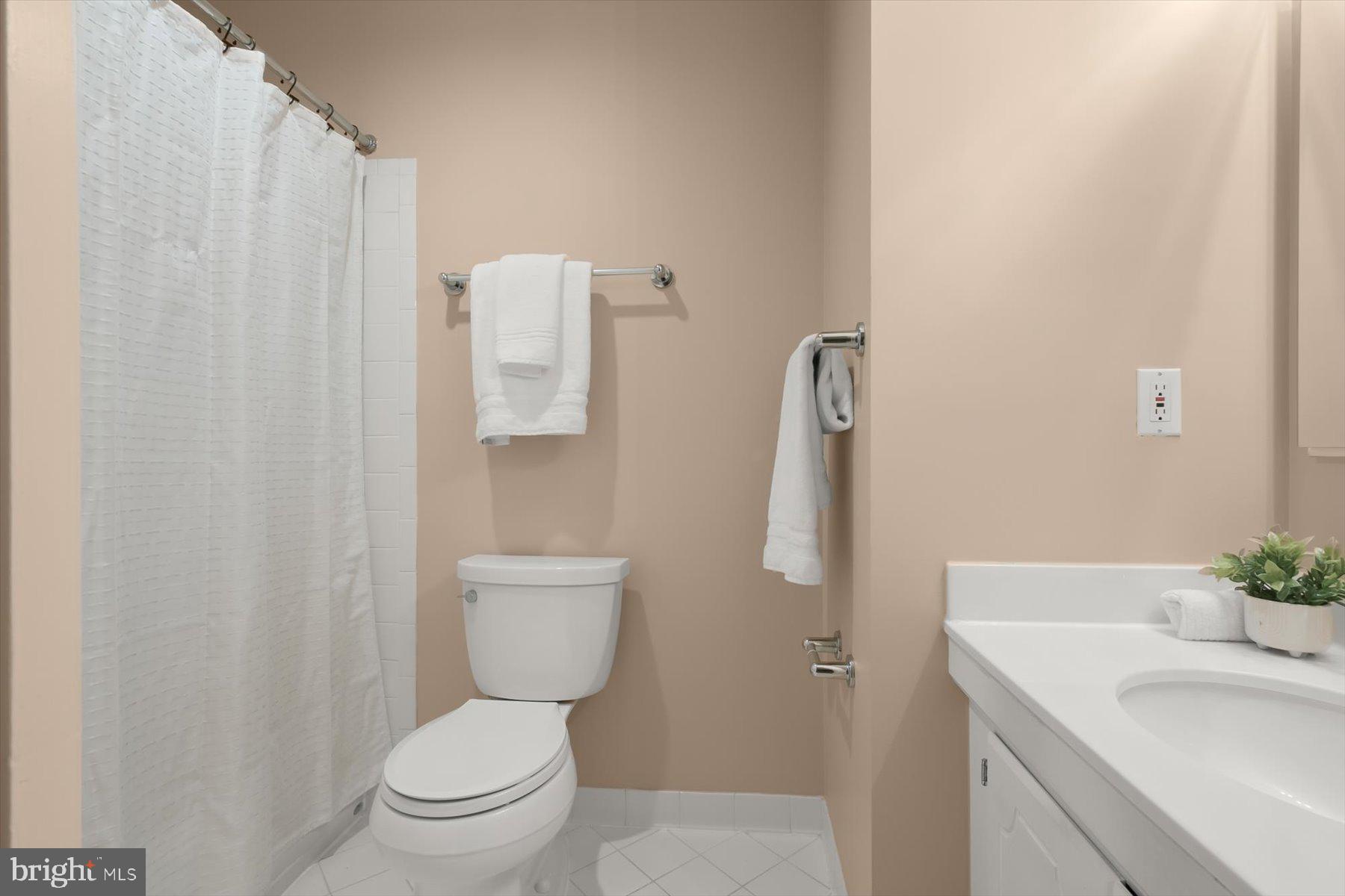 1727 Glastonberry Road Potomac, MD 20854 - Photo 34 of 45 a bathroom with a sink a toilet and shower curtain