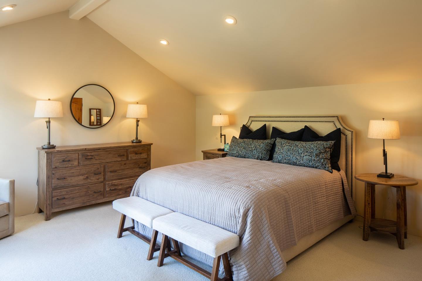 9546 Maple Court Carmel, CA 93923 - Photo 18 of 27 a bedroom with a bed a mirror on dresser and a table