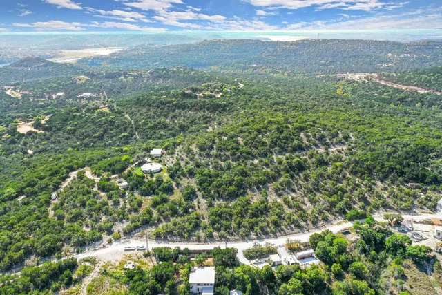 a backyard of a house with lots of green space and a fountain