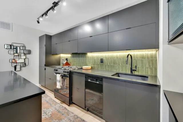 a view of kitchen island with stainless steel appliances cabinets and wooden floor