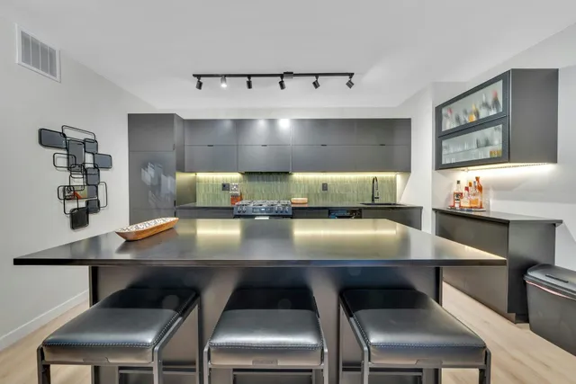 a kitchen with stainless steel appliances kitchen island granite countertop a refrigerator and cabinets