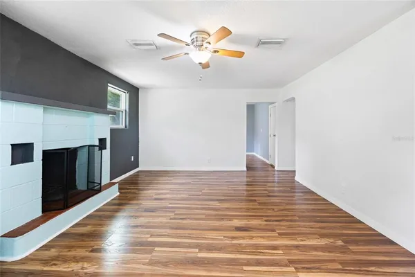 a view of an empty room with wooden floor