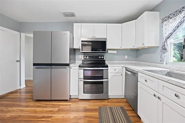a kitchen with wooden cabinets and stainless steel appliances