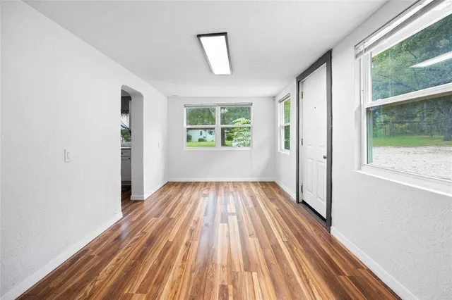a view of a room with wooden floor and a window