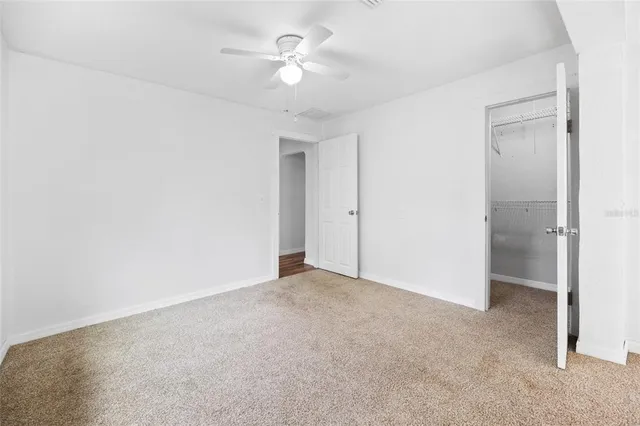 an empty room with fan and a ceiling fan