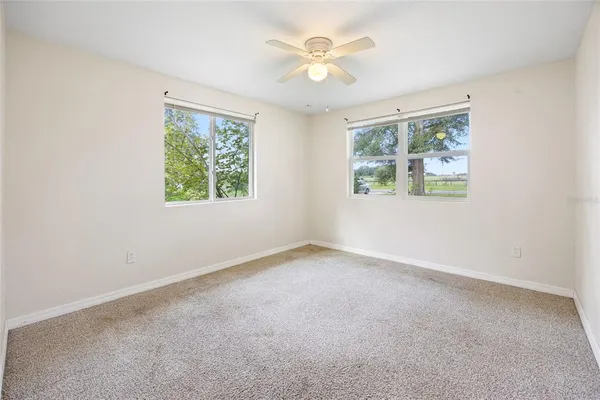 an empty room with a window and a fan