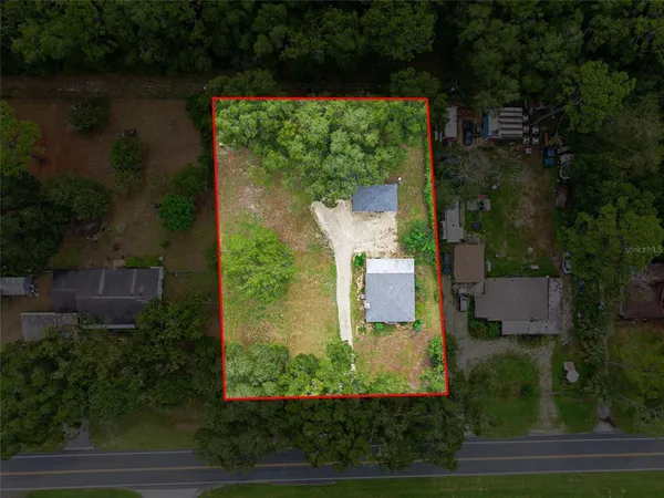 an aerial view of a house with a yard and lake view