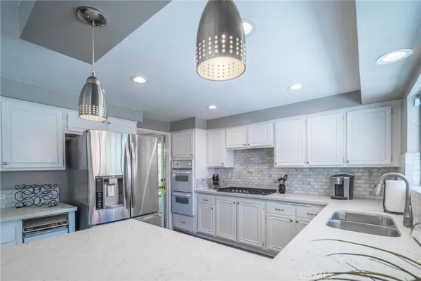 a kitchen with stainless steel appliances granite countertop a refrigerator and a stove top oven