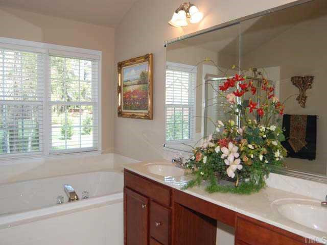 9308 Naples Court Raleigh, NC 27617 - Photo 7 of 12 The master bath has a vaulted ceiling, ceramic floor, track light, vanity lights, double mirrored medicine cabinet, cultured marble double sink with cherry cabinets, garden tub with tile surround, walk in shower, linen closet and an exhaust fan Other