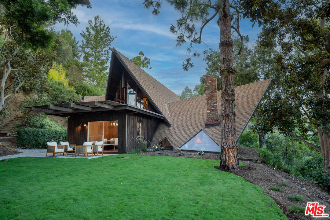 1963 Mandeville Canyon Road Los Angeles, CA 90049 - Photo 7 of 46 a front view of a house with garden