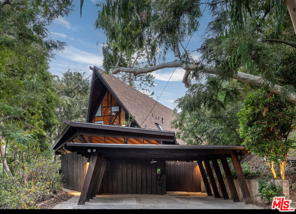 1963 Mandeville Canyon Road Los Angeles, CA 90049 - Photo 8 of 46 a view of a wooden house with large trees