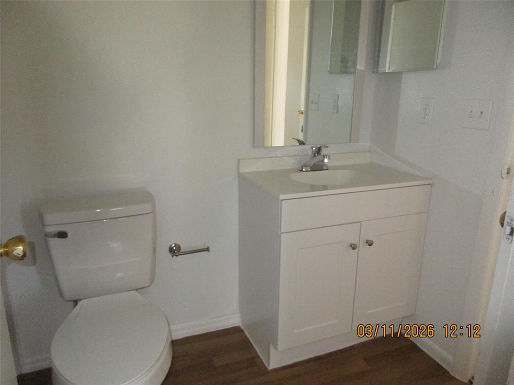 131 Jones Lane, Unit A Kissimmee, FL 34743 - Photo 22 of 23 a bathroom with a toilet sink and mirror
