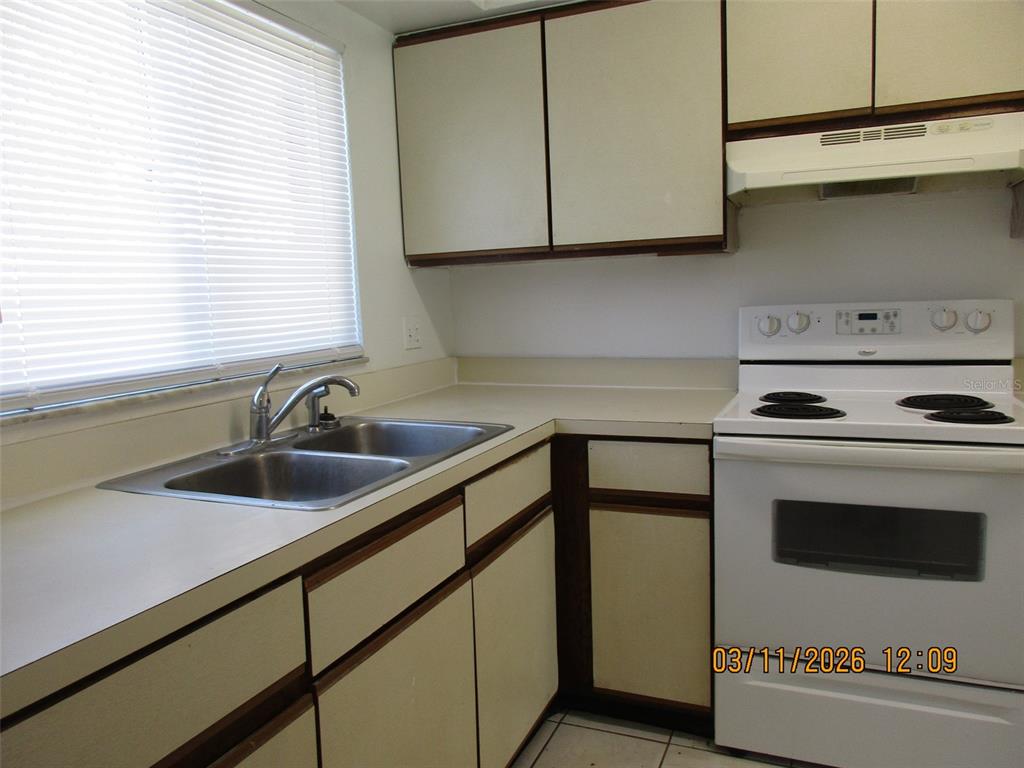 131 Jones Lane, Unit A Kissimmee, FL 34743 - Photo 9 of 23 a kitchen with a sink cabinets and a window