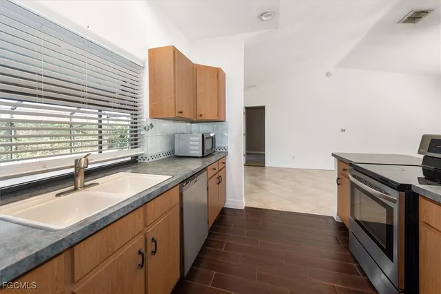 a kitchen with a sink stove top oven and cabinets