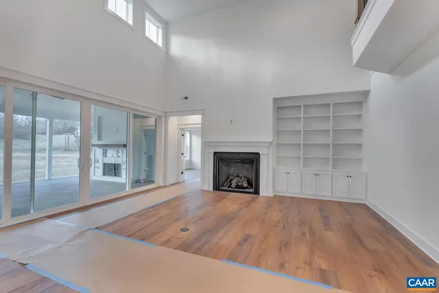 an empty room with wooden floor and fireplace