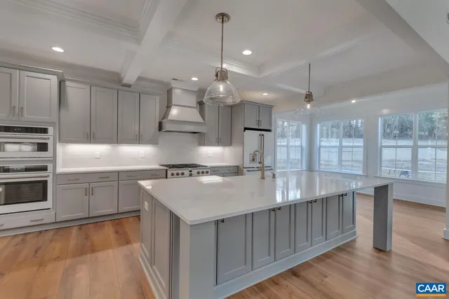 a kitchen with kitchen island a counter top space a sink stainless steel appliances and cabinets