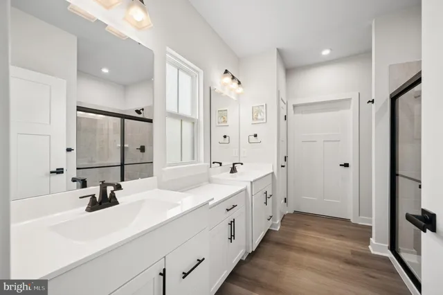 a bathroom with double vanity sinks and a mirror