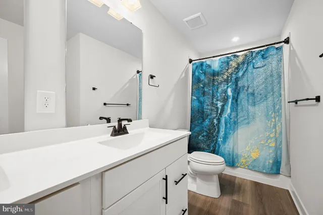 a bathroom with a sink a toilet and a mirror