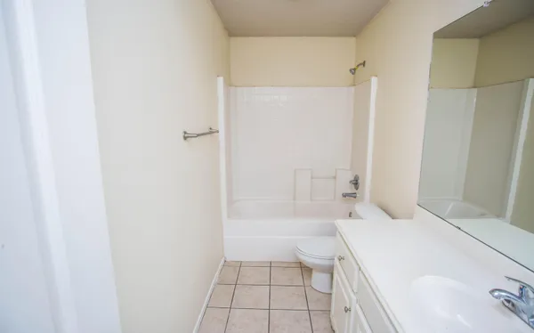 a bathroom with a tub shower and a sink