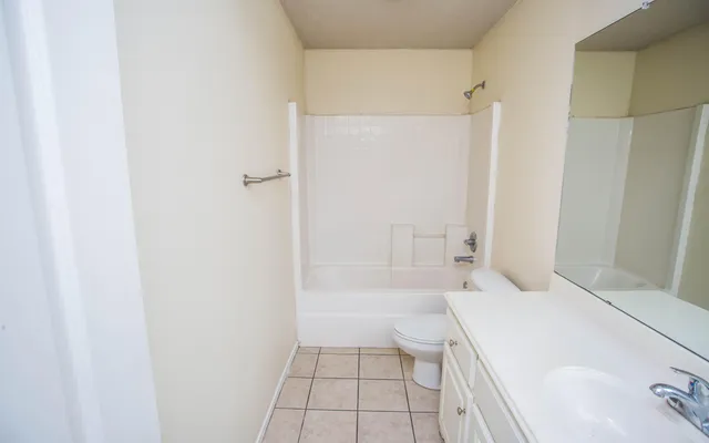 a bathroom with a tub shower and a sink