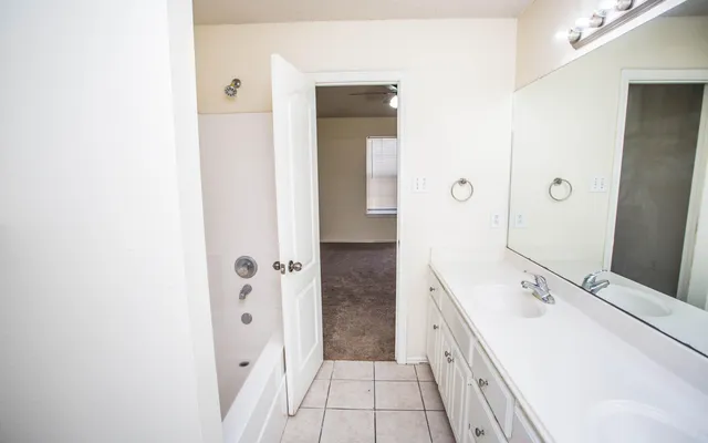 a spacious bathroom with a double vanity sink and a mirror