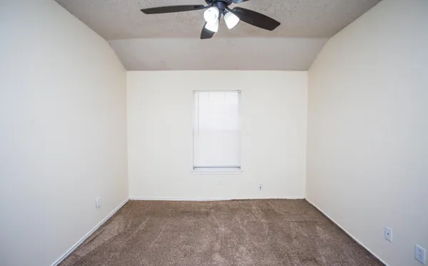 an empty room with a chandelier fan