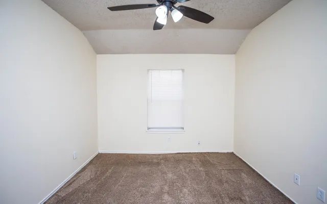 an empty room with a chandelier fan
