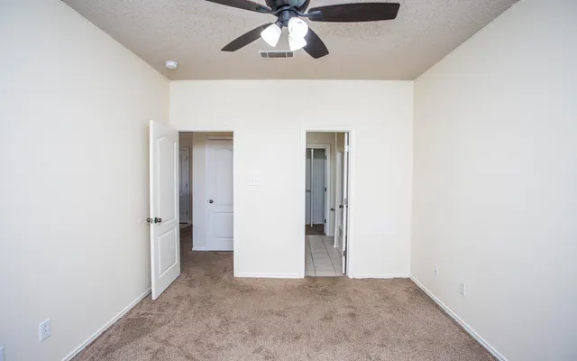 a view of a hallway with a chandelier fan