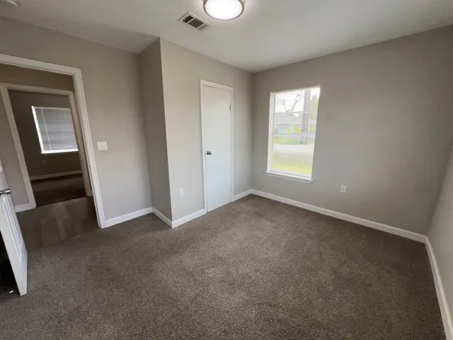 an empty room with windows and closet