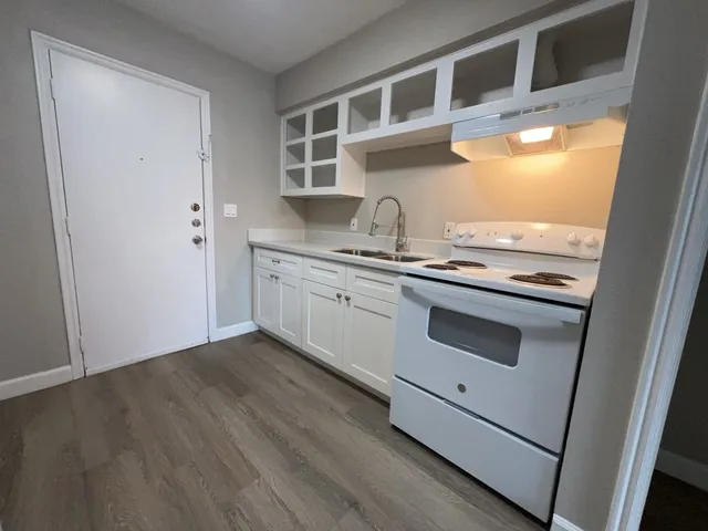 a kitchen with stainless steel appliances granite countertop a stove a sink and a microwave