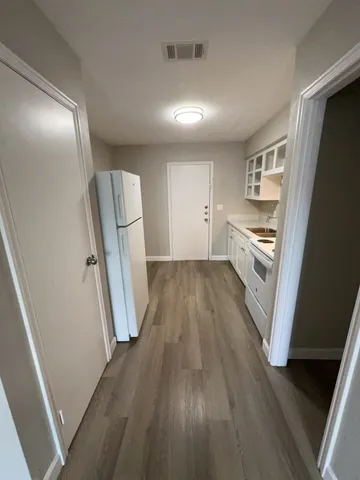 a view of a kitchen with wooden floor and stainless steel appliances